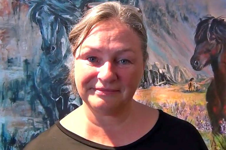 Icelandic Artist Bertha Kvaran in front of two of her paintings of Icelandic horses